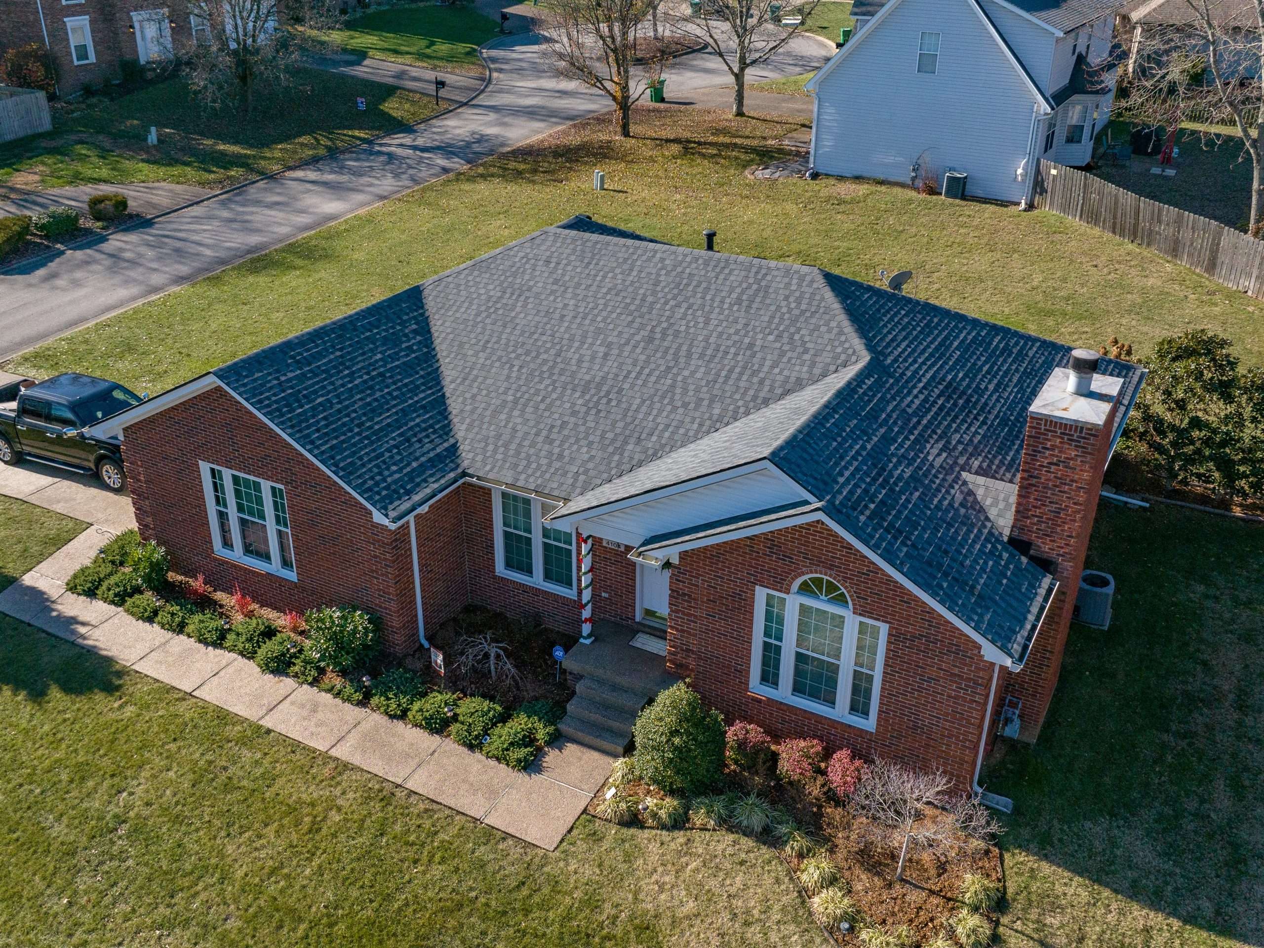 A brick home featuring a newly installed roof by AIC Roofing, ensuring durability and style.