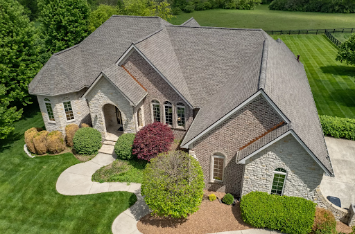 Large stone home in Richmond, KY with a newly installed asphalt shingle roof by AIC Roofing.