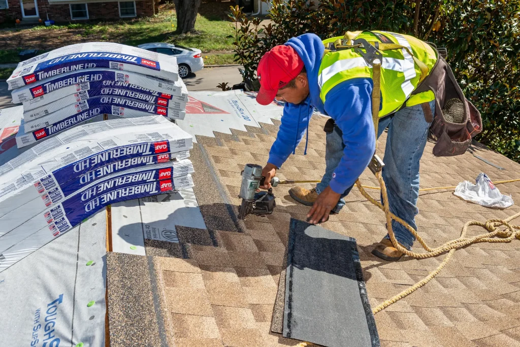 Professional roofer installing GAF Timberline HD shingles, ensuring a durable and high-quality roof replacement.