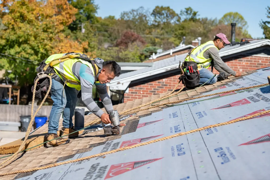 Expert roofing installation with special offers available. Roofing contractors performing roof replacement with safety harnesses on a residential home in Louisville, KY