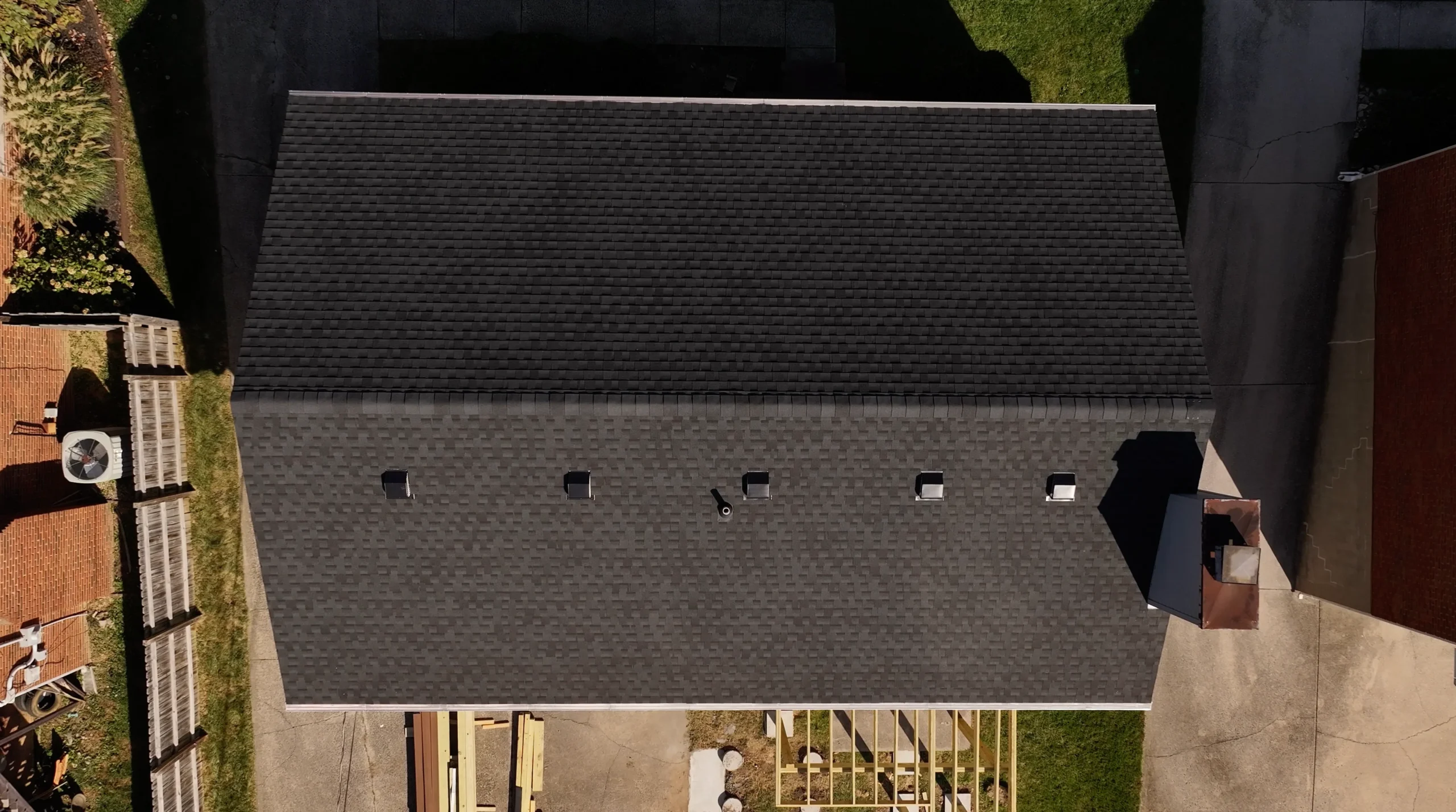 Aerial view of a new roof replacement featuring GAF Timberline HDZ shingles in Charcoal, installed by a local roofing contractor.