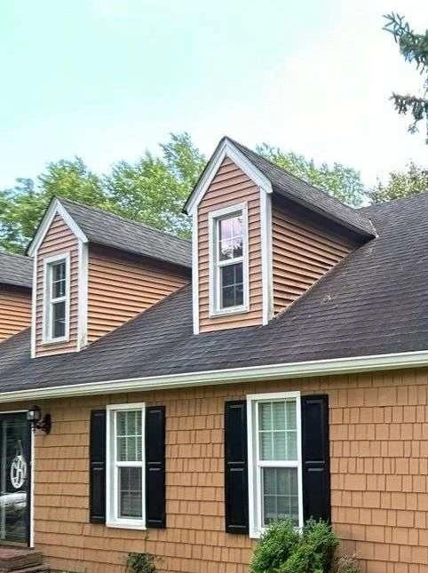 Close-up of repaired dormers with new siding on a residential home in Lexington, KY, showcasing AIC Roofing & Construction’s quality siding installation.
