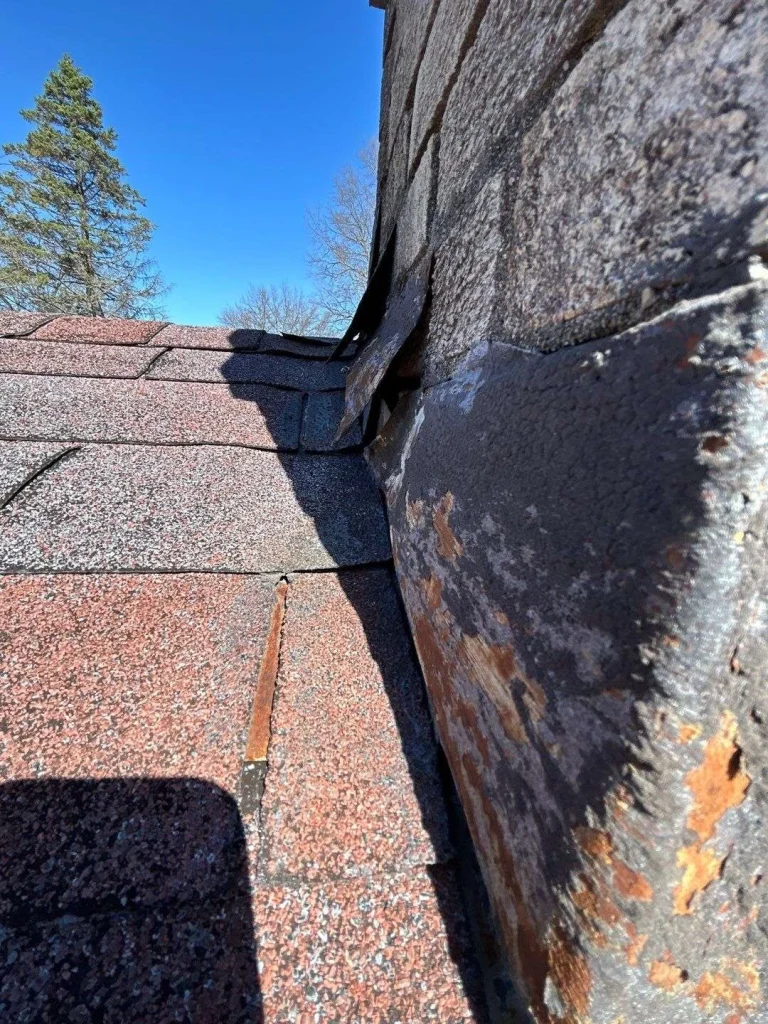 Repair your worn chimney flashing. A chimney on a roof in Lexington, KY, showing the need for professional roofing repair by AIC Roofing & Construction.
