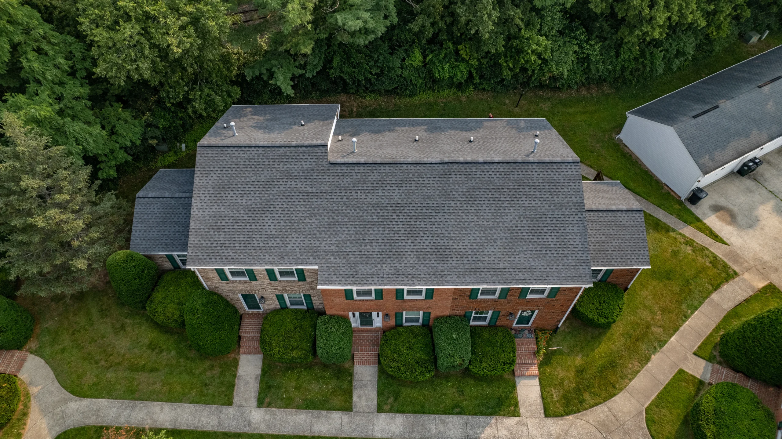 A newly installed Pewter Gray shingle roof on a Versailles, Kentucky apartment complex, completed by AIC Roofing & Construction for multifamily roof repair and apartment roof replacement.