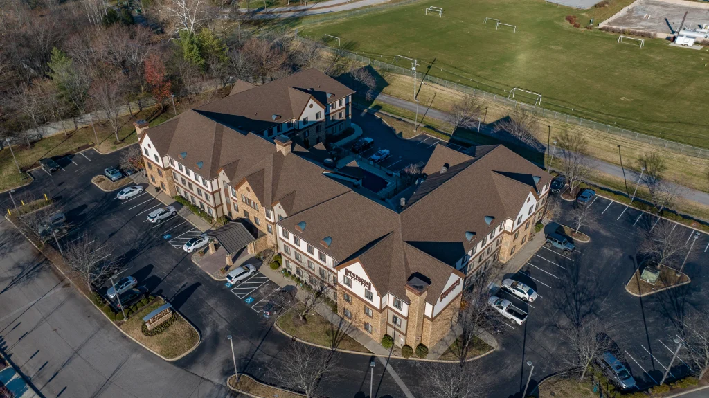 Aerial view of a large commercial building with a newly replaced roof, showcasing professional commercial roofing services.