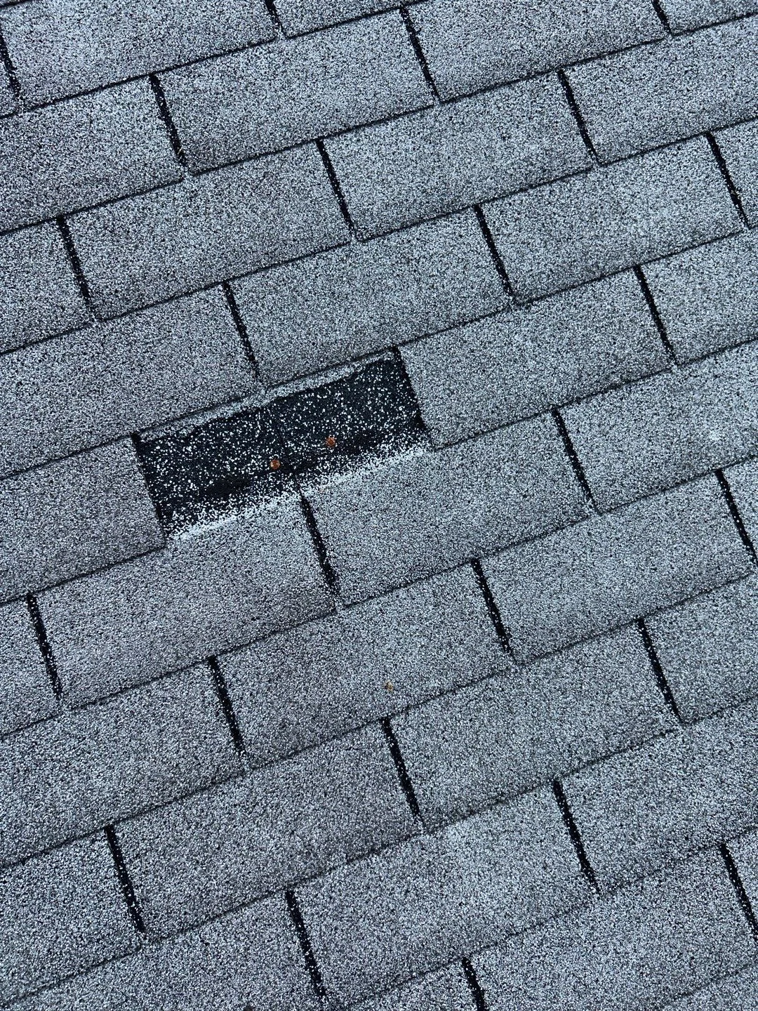Close-up of missing shingle on a residential roof in Lexington, KY, highlighting the need for professional roof repair by AIC Roofing & Construction.