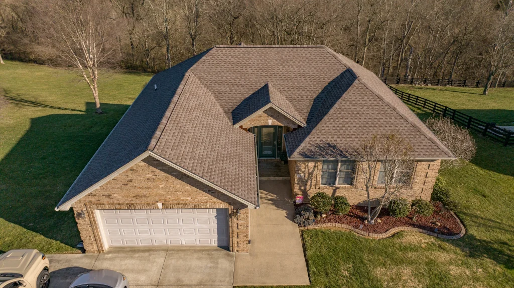 A beautiful brick home showcasing a recently replaced roof, ideal for estimating roof replacement costs.