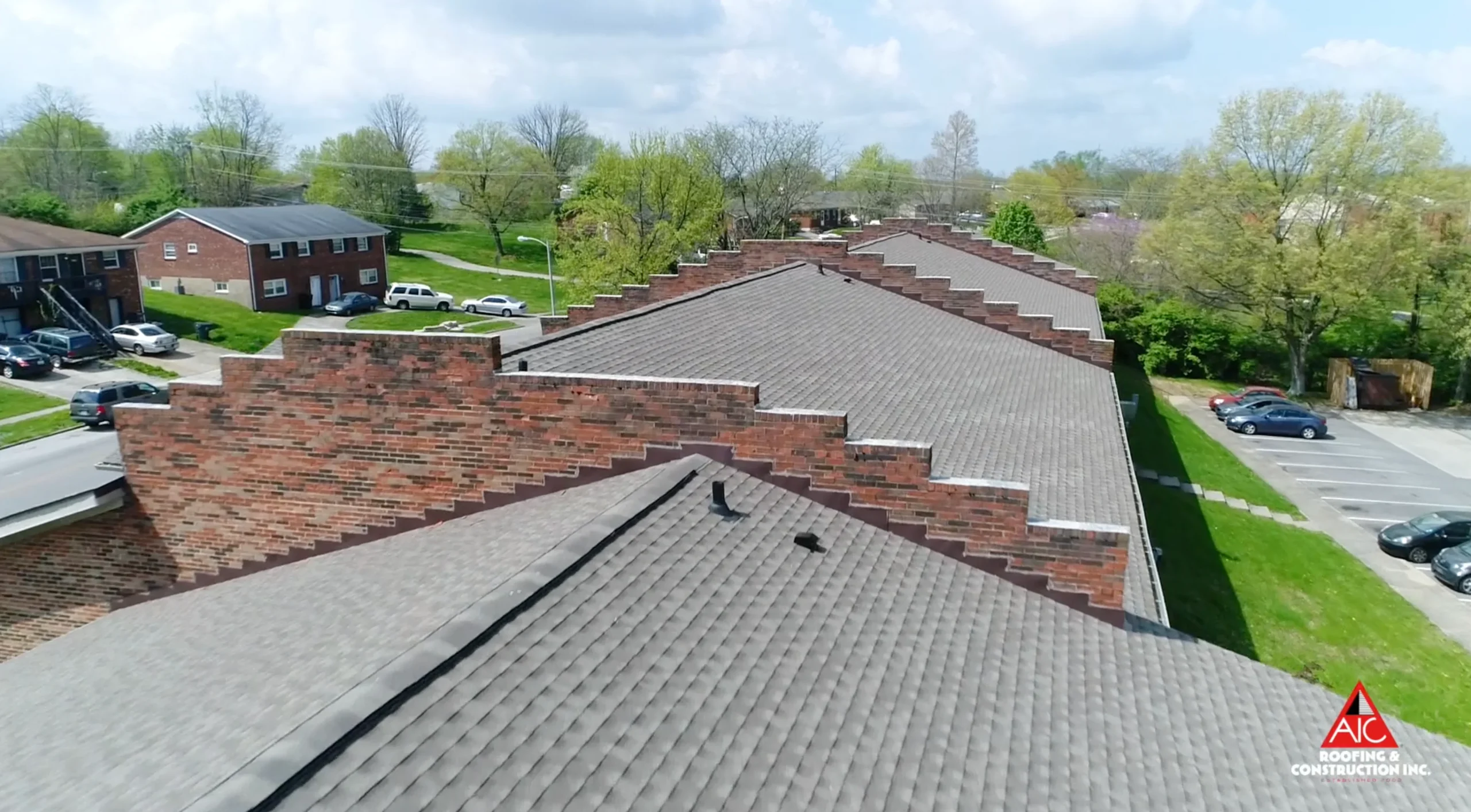 Close-up aerial view of a Lexington, KY apartment roof replacement featuring Weathered Wood shingles, installed by AIC Roofing & Construction, a trusted shingle roofing contractor.