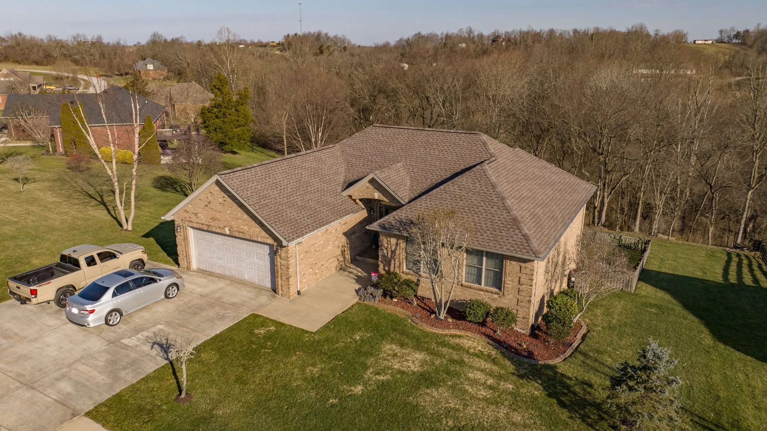 A beautiful brick home with a recently installed Mission Brown roof, showcasing expert work by a Richmond roofing contractor.