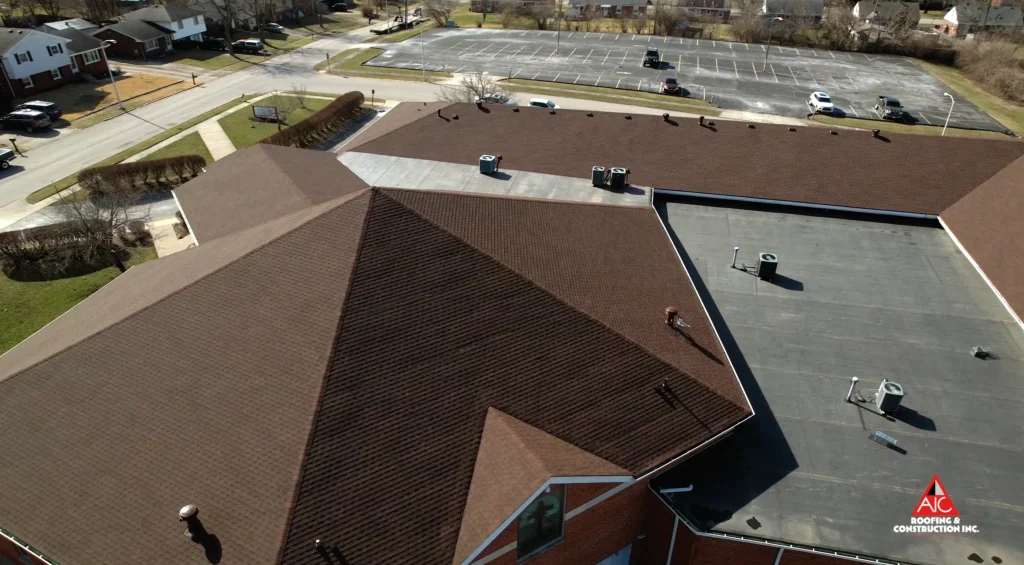 Aerial View of a Church Roof Featuring New Shingles and Flat Roofing