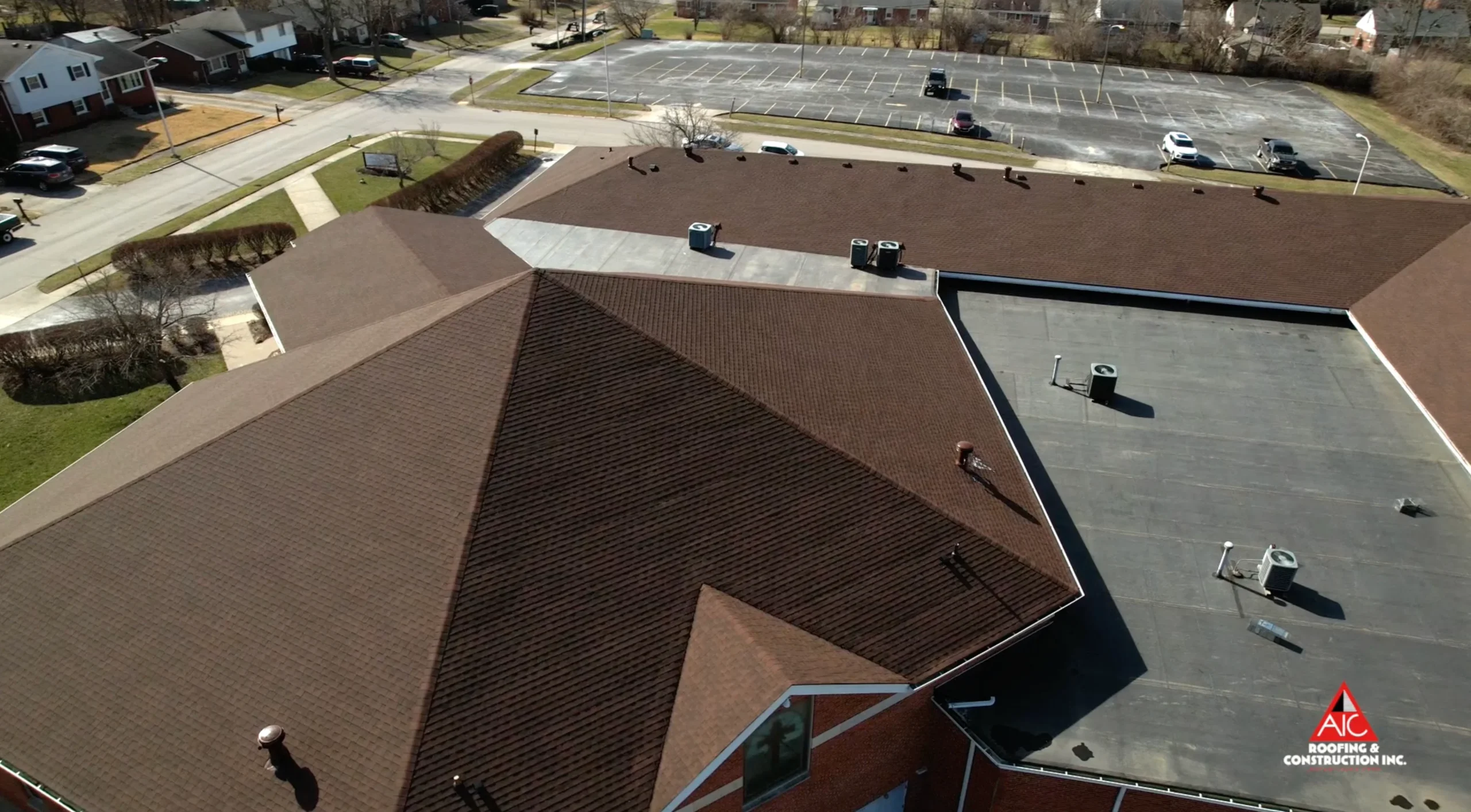 Aerial View of a Church Roof Featuring New Shingles and Flat Roofing