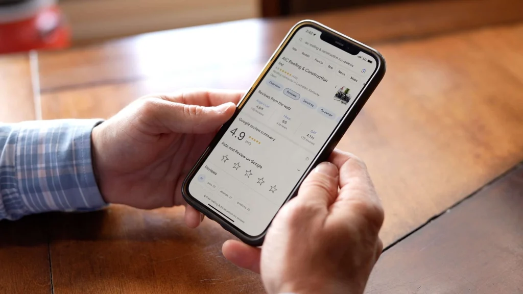 A customer viewing a 4.9-star Google review for AIC Roofing & Construction Inc. on a smartphone, highlighting the company's reputation as an experienced roofing contractor.