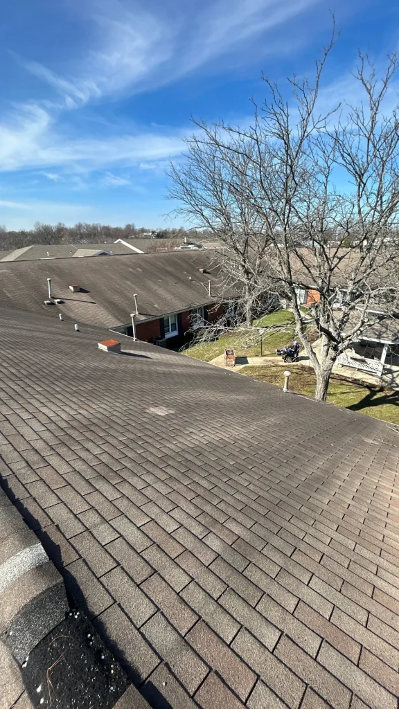 example of discolored shingles Wide view of aging shingle roofing on a commercial building in Lexington KY, showing signs of wear and potential roof damage.