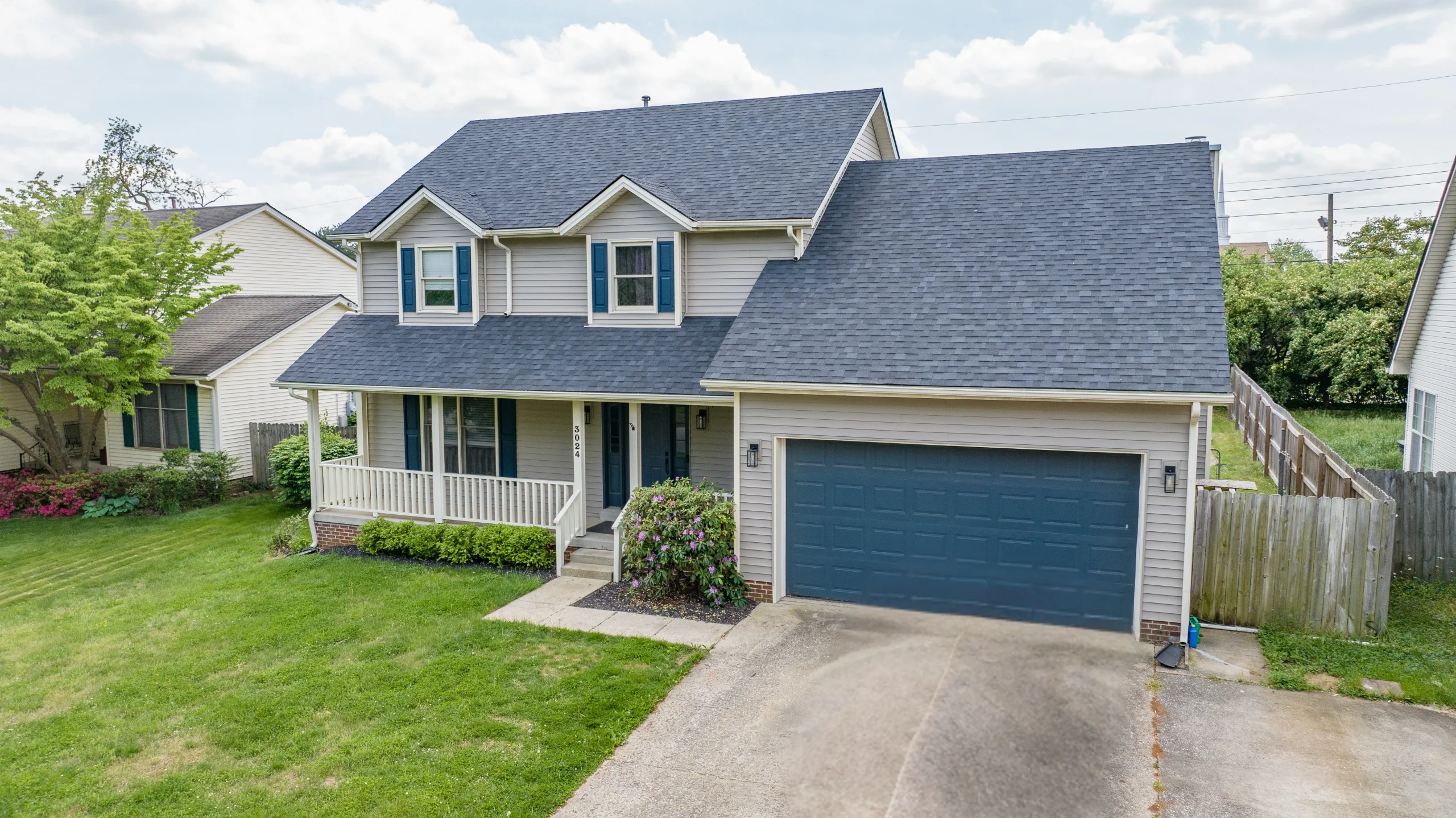 Front view of a two-story home in Lexington KY with fresh siding and roofing, showcasing professional exterior work.