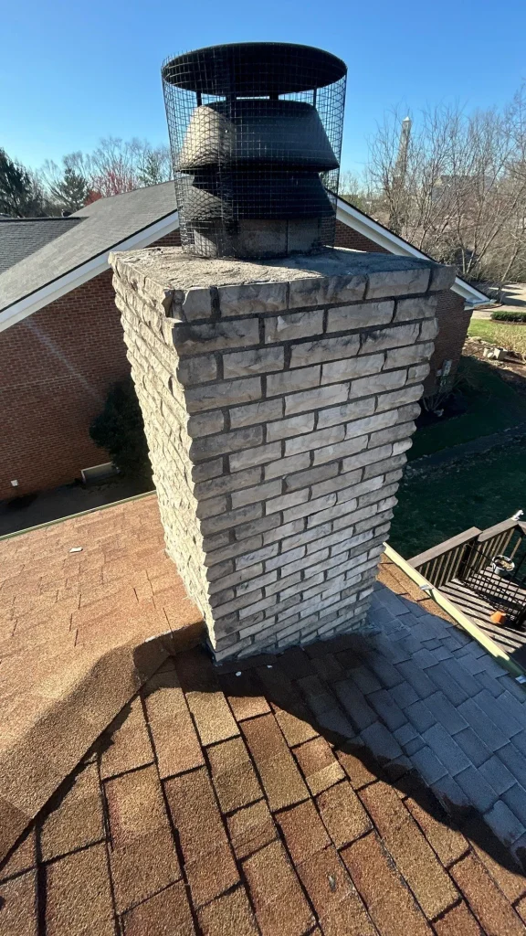 example of chimney repair Close-up of a brick chimney on a shingle roof showing signs of flashing wear, a common cause of leaking chimneys in Lexington KY.