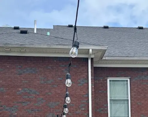Close-up view of a newly installed white gutter system on a brick home in Bardstown, KY.