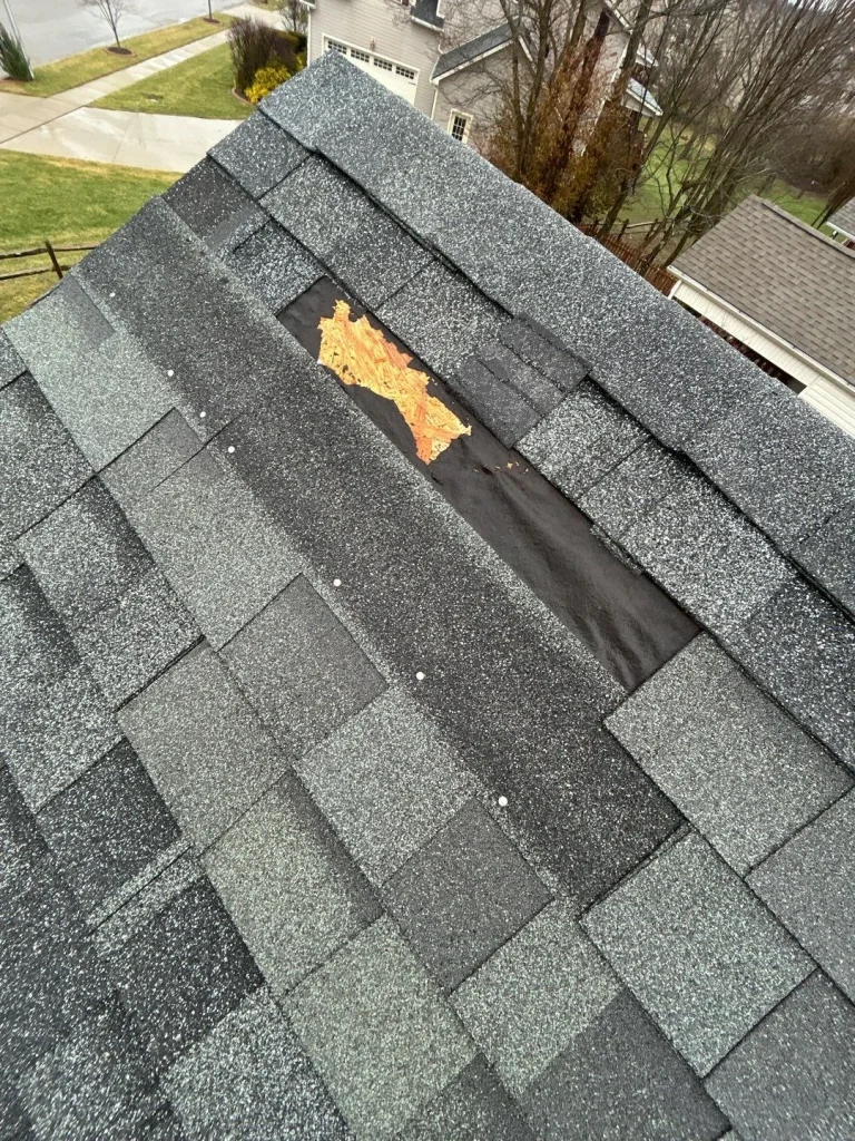Exposed roof decking and underlayment from missing shingles on a commercial roof