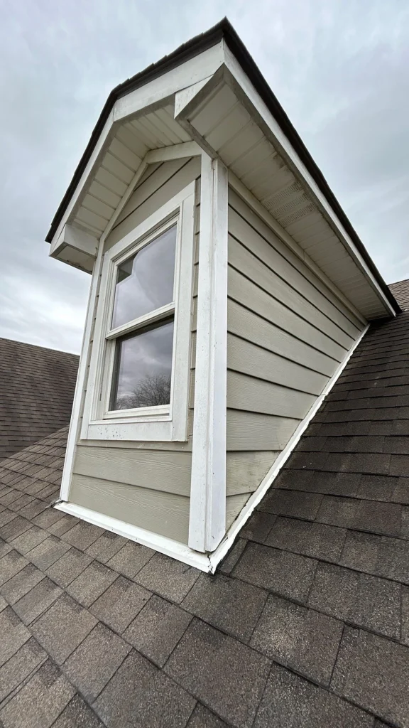 Dormer window with visible water damage signs at the roofline, suggesting the need for roof leak repair in Louisville.