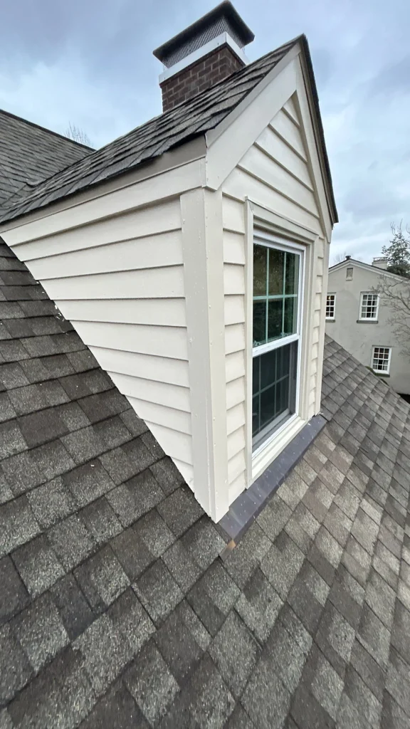 White dormer on shingle roof missing flashing, a common cause of leaky roof needing repair in Richmond KY
