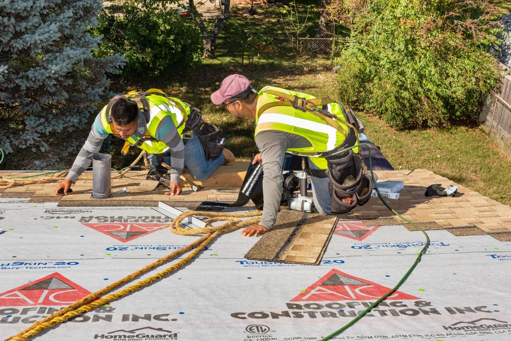 Roof replacement underway in Richmond KY with crew from AIC Roofing & Construction installing new shingles over underlayment.
