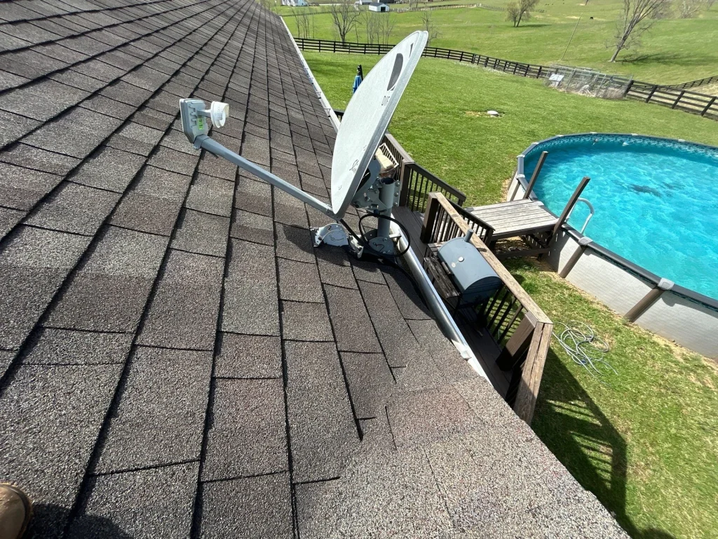 Satellite dish mounted on shingle roof with signs of wear, indicating a potential need for roof repair in Louisville, KY.