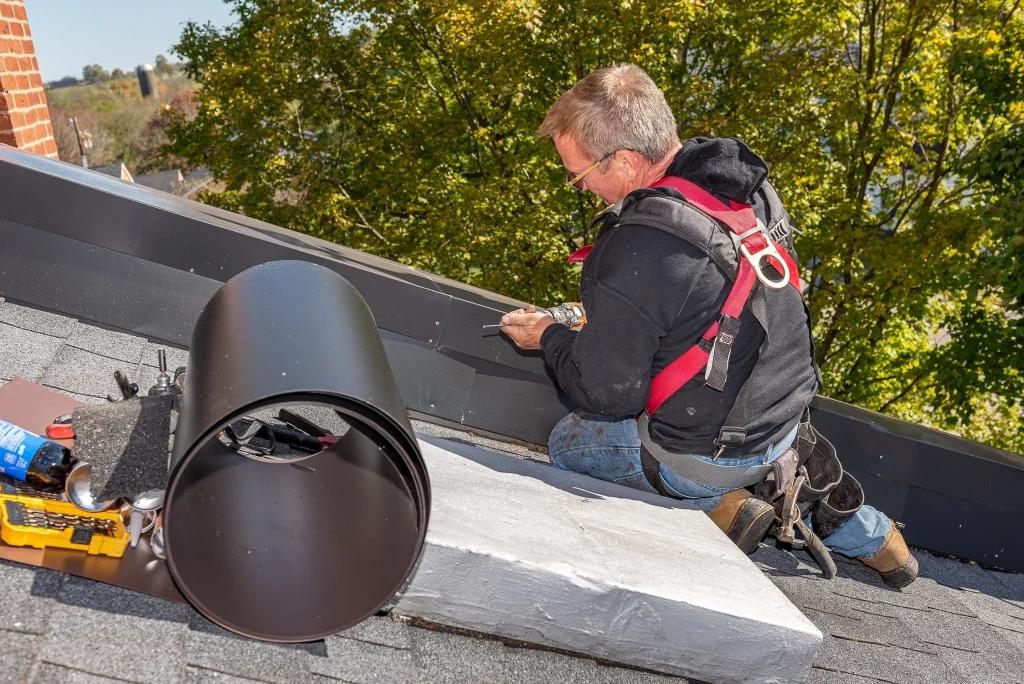 Roofing contractor in Richmond KY working on detailed roof leak repair near flashing and vent area.