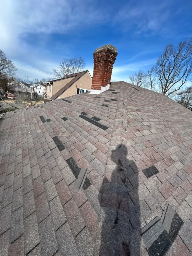 Damaged shingle roof near chimney needing repair in Richmond, KY.