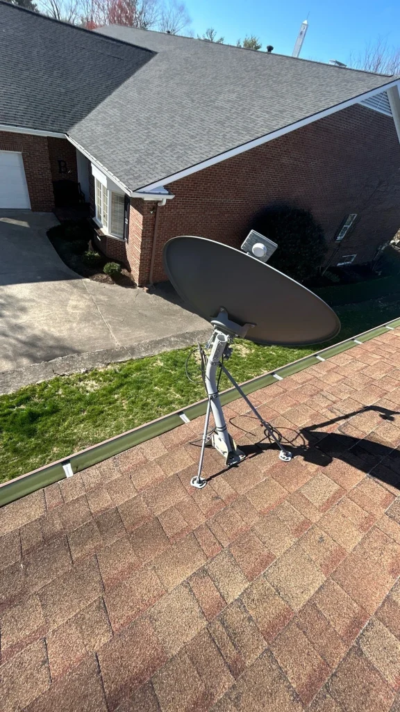 Satellite dish mounted on shingle roof potentially causing a leak, requiring roof repair by a Richmond KY roofing contractor