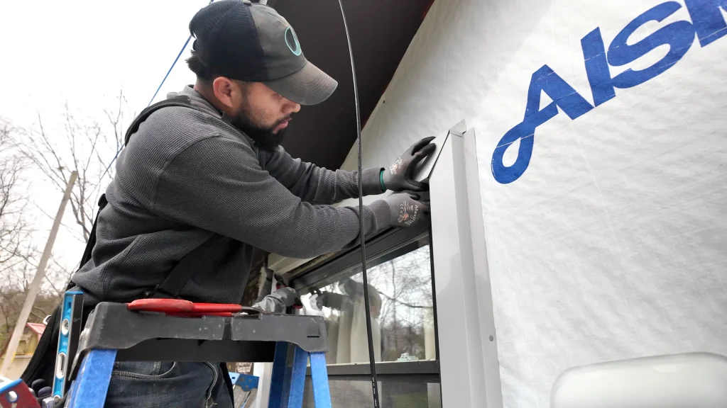 Professional siding contractor in Louisville KY installing trim around a window during siding repair
