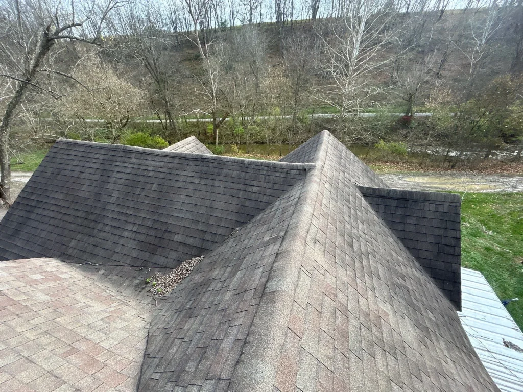 Discolored shingles and debris buildup indicating roof damage on a Richmond KY home