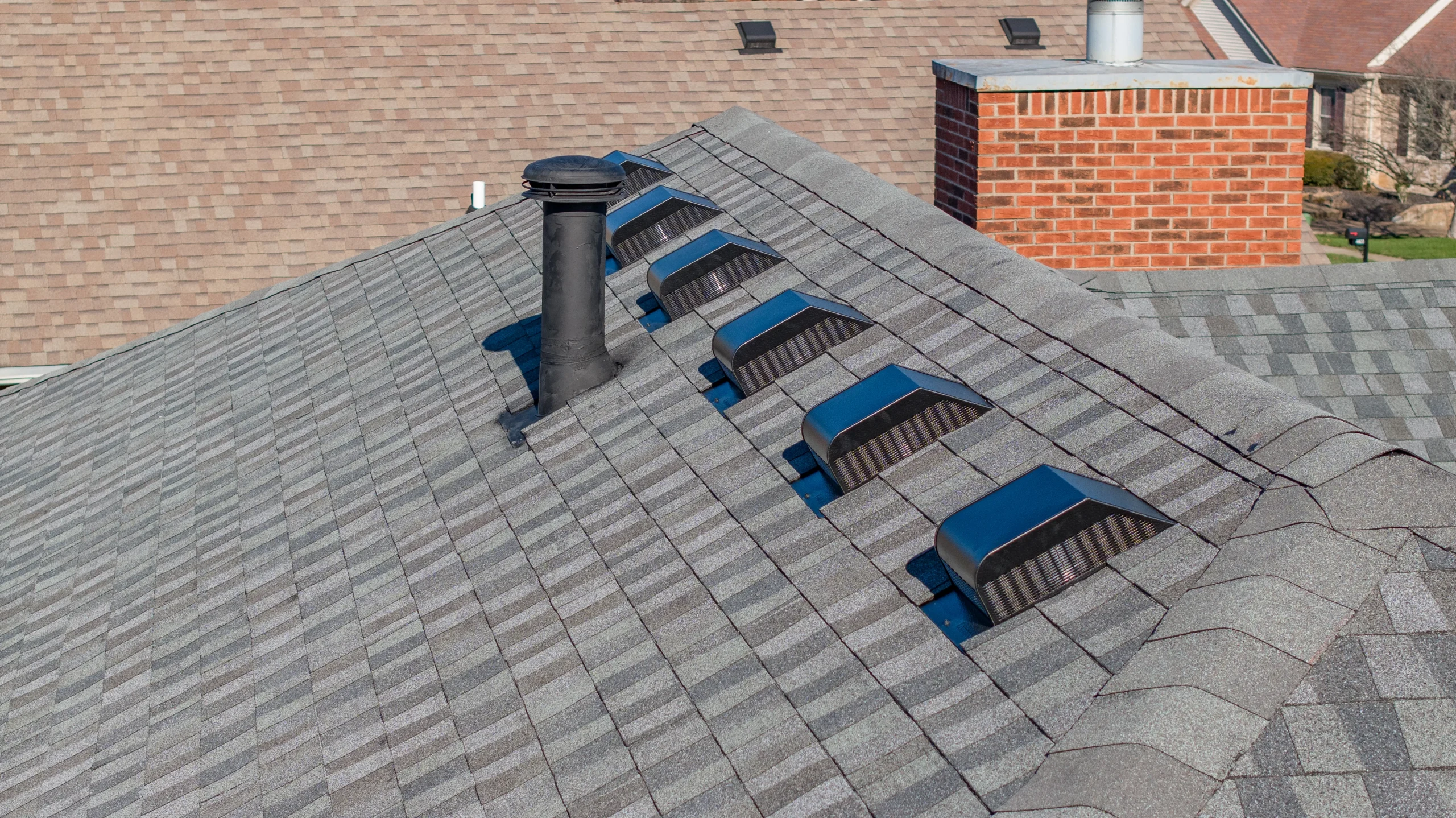 Close-up of shingle roof in Louisville KY showing roof vents and pipe boot, common points of leaks and storm damage.