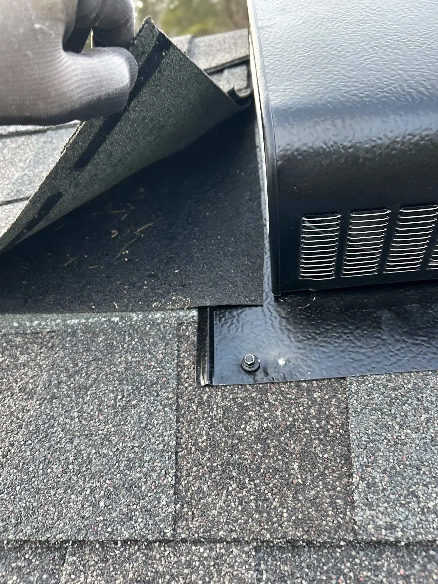 Roof inspection showing lifted asphalt shingle next to a black metal roof vent on a home in Shepherdsville, KY.