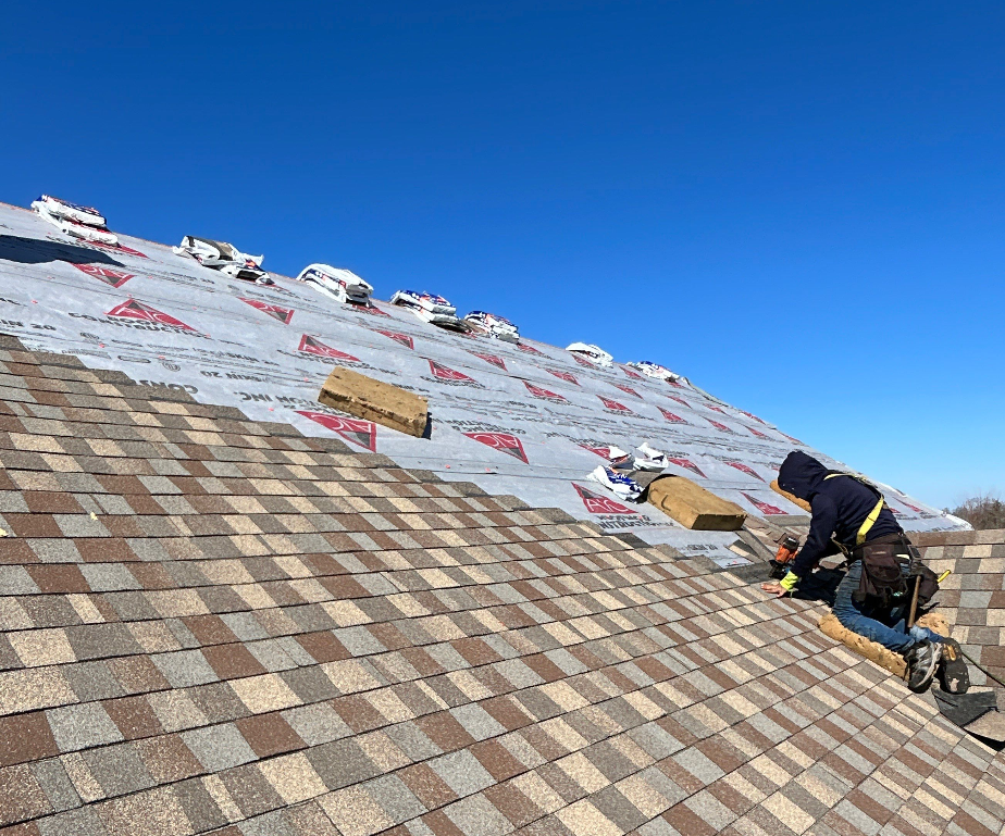 Roof repair in progress on a Lexington, KY home, showing a worker from AIC Roofing installing new asphalt shingles over underlayment.