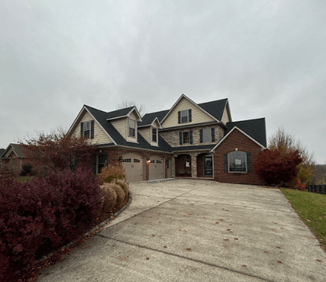 Two-story brick and siding home with dark gray shingle roof, located in Richmond, KY.