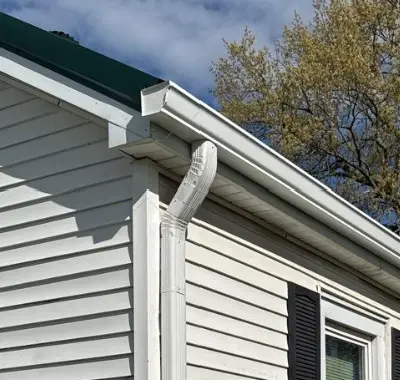 New white gutter system installed on the side of a home in Kentucky by AIC Roofing