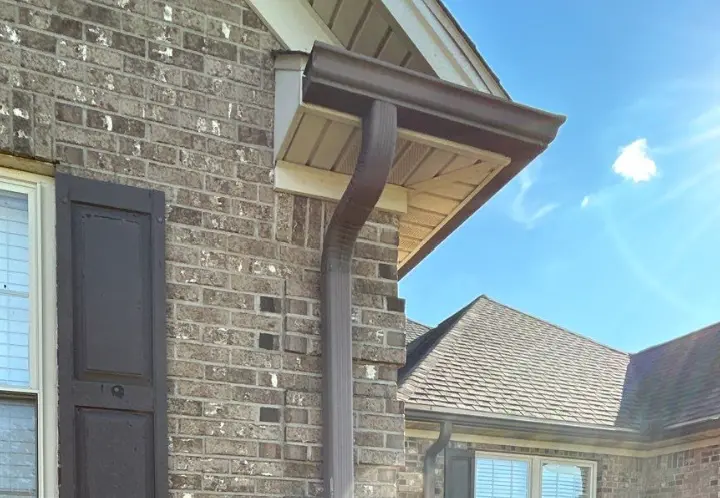 Close-up of a brown gutter system installed on a Richmond home by AIC Roofing & Construction.