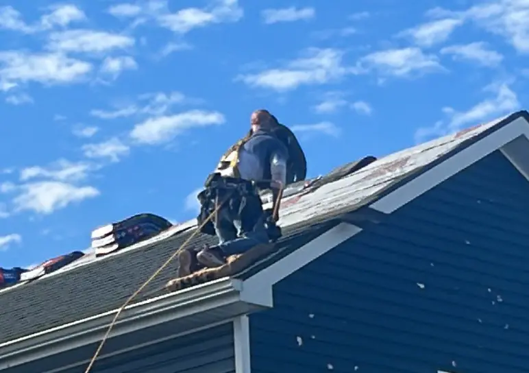 Two AIC Roofing & Construction crew members repairing a roof on a Richmond home.