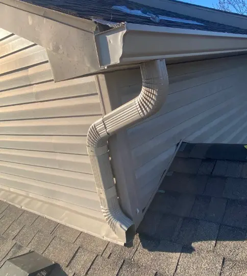 Close-up of a new beige gutter system installed on a Richmond home by AIC Roofing & Construction.
