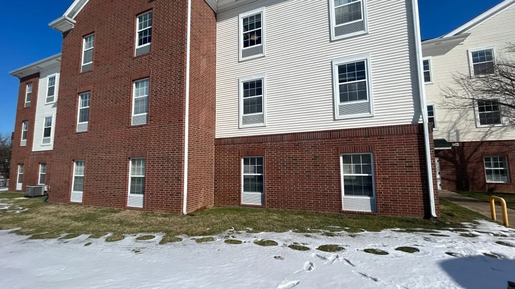 Multi-unit residential building in St. Matthews, KY featuring a combination of red brick and white vinyl siding.