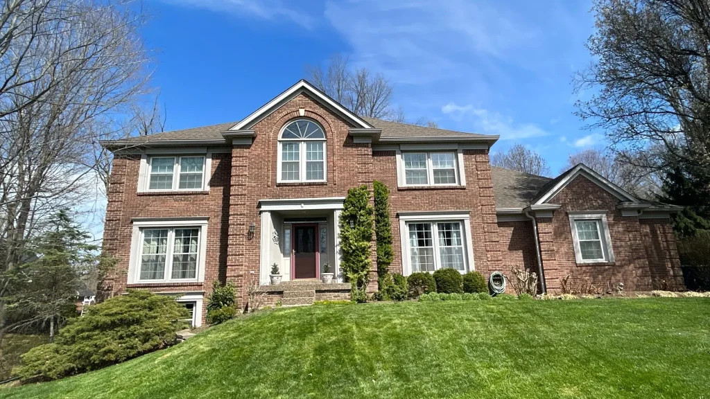 Two-story brick home in Crestwood, KY with a new roof installed by AIC Roofing & Construction.