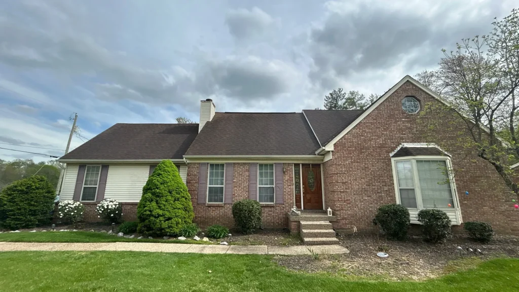 Brick and siding home with a newly replaced roof by AIC Roofing & Construction.