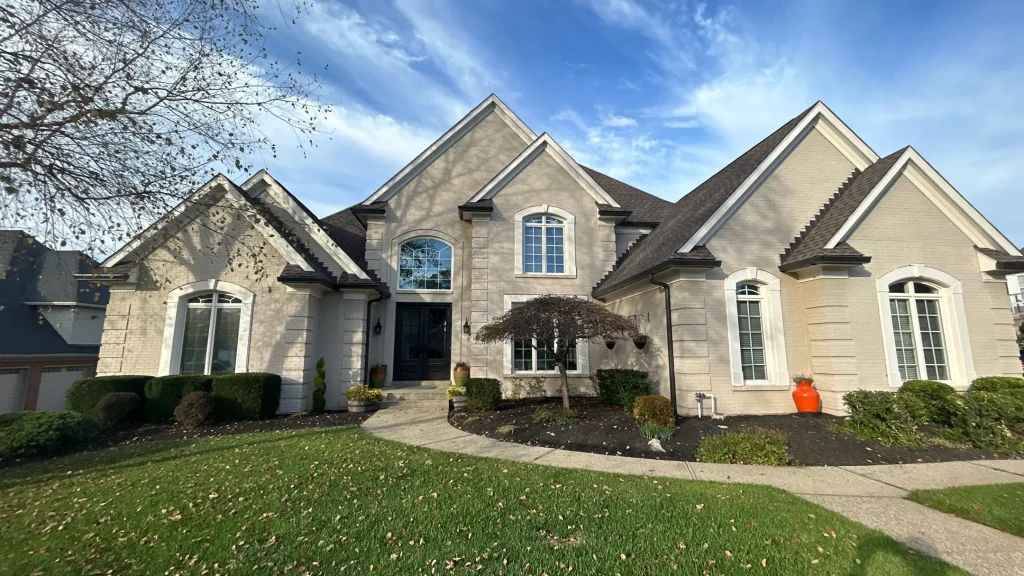 Large light brick home in Prospect, KY with a newly replaced roof by AIC Roofing & Construction.