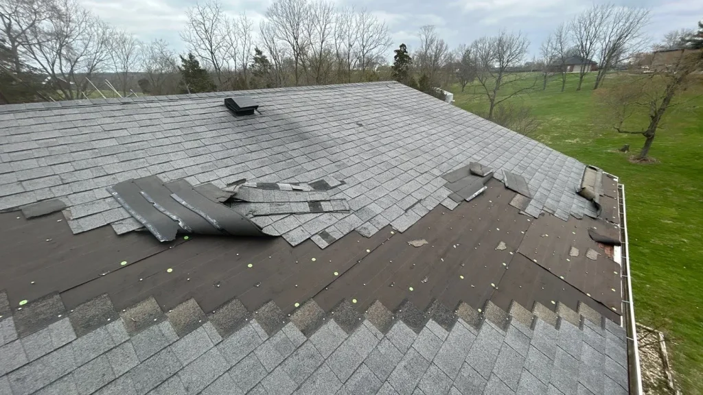 Partially repaired roof with exposed decking during a roofing project in Bloomfield, KY by AIC Roofing & Construction.