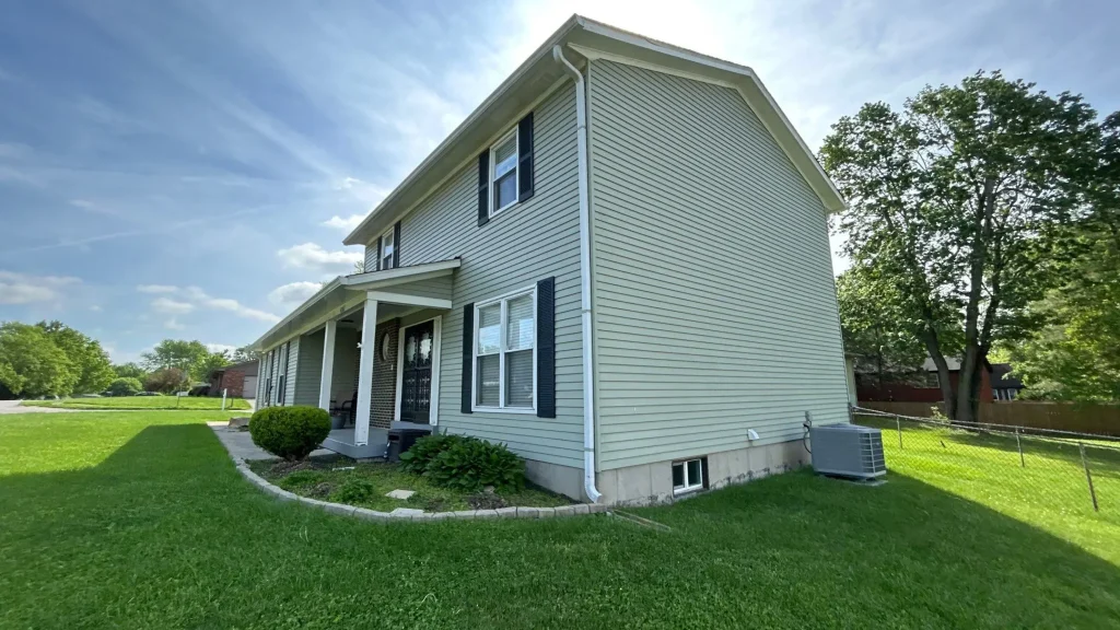 Two-story home with newly replaced vinyl siding in Jeffersonville, IN by AIC Roofing & Construction.