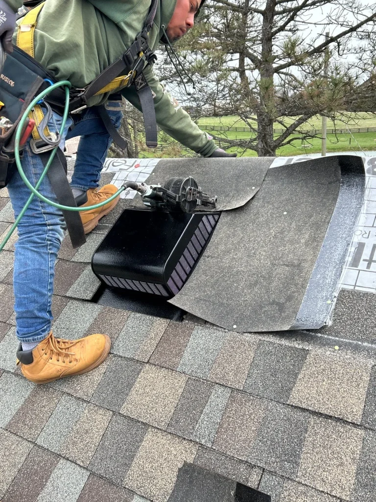 Roofer installing a ridge vent on a shingled roof during a repair in Cox’s Creek, KY by AIC Roofing & Construction.