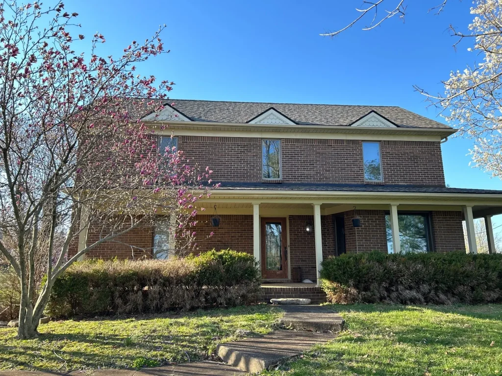 Two-story brick home with new roof replacement by AIC Roofing & Construction in Cox’s Creek, KY