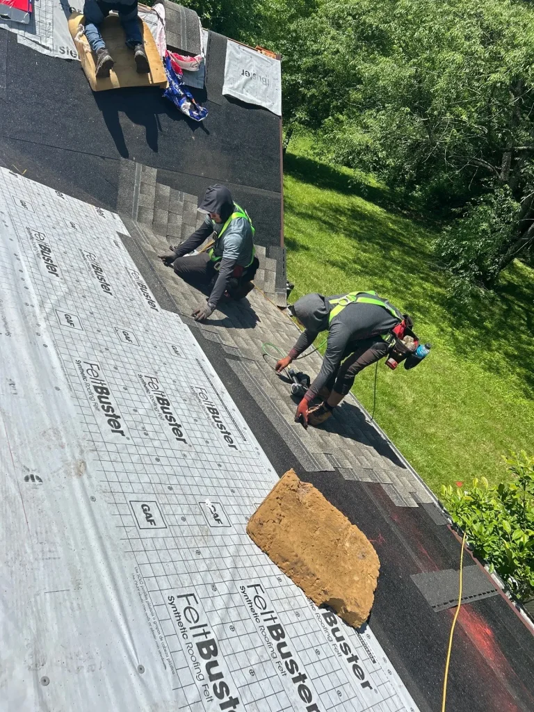 Roofers installing shingles on a Lexington home during a roof repair project, using FeltBuster underlayment.