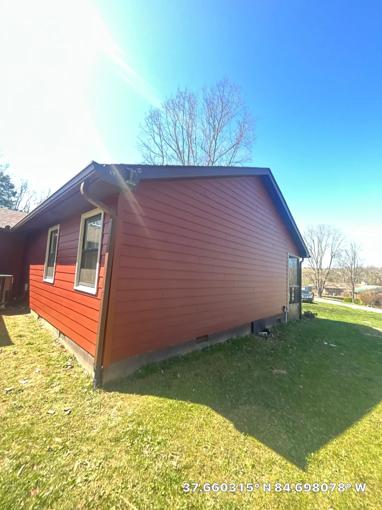Side view of a Lexington home with new red siding and brown trim installed by AIC Roofing & Construction.