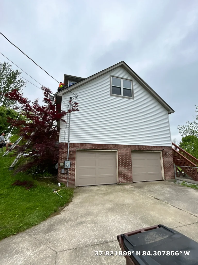 Richmond home with newly installed siding and a brick garage by AIC Roofing & Construction.