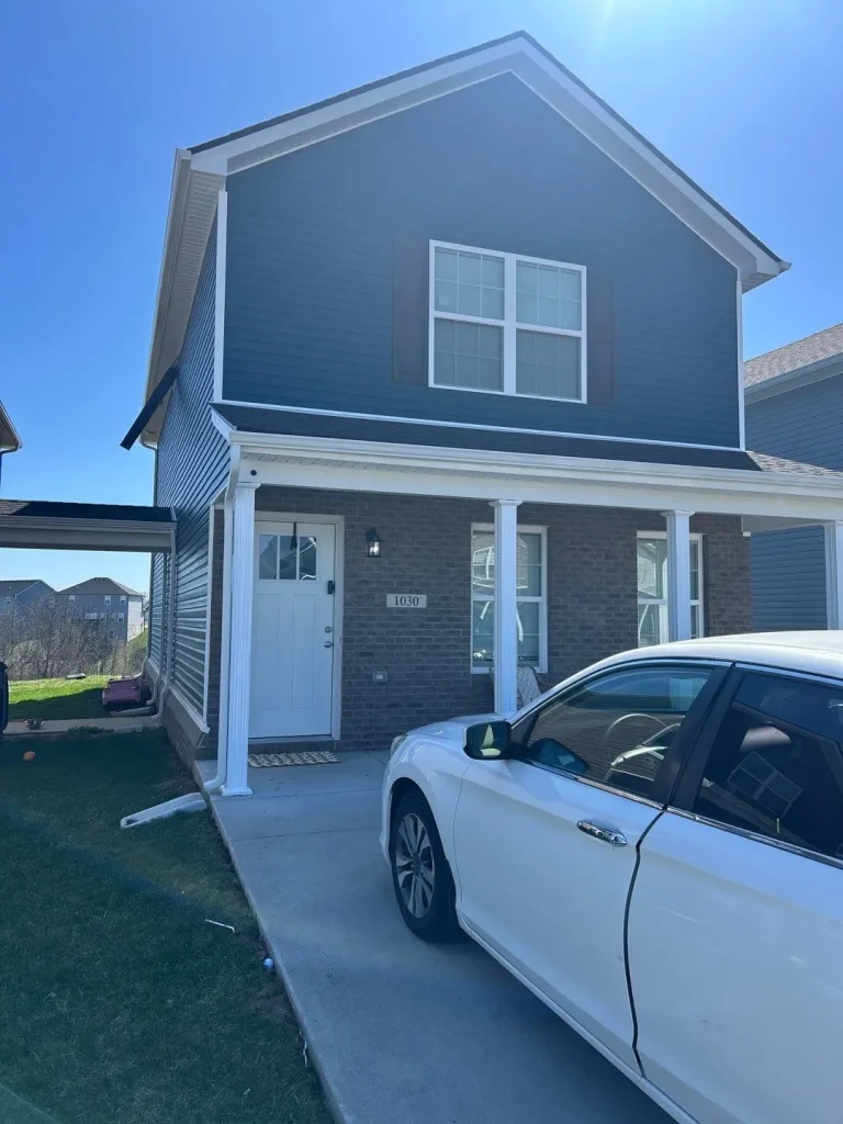 New siding installation on a two-story blue Richmond home by AIC Roofing & Construction.